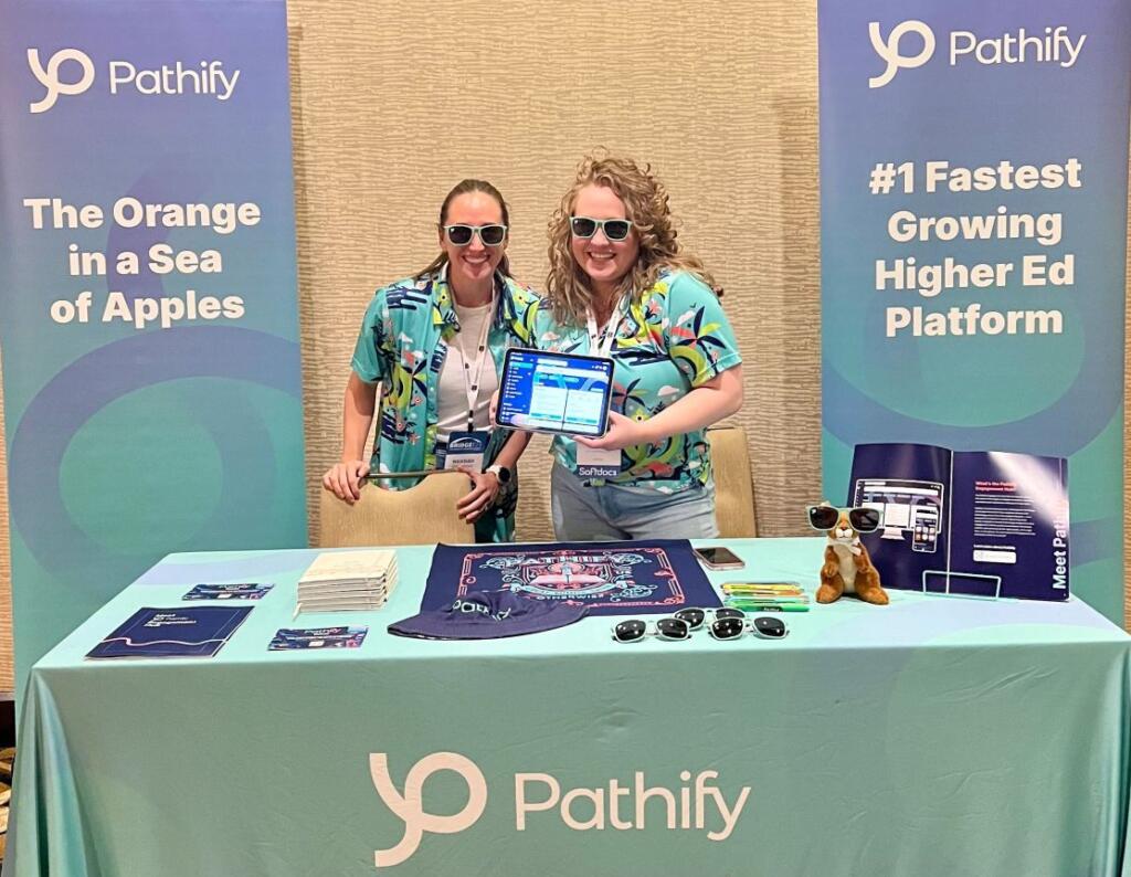 Two women standing at a Pathify-branded booth